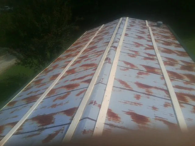 Rusted metal roof panels with new wood purlins before replacement — Storm Damage Roof Repair in Reedville by Roofing Brothers