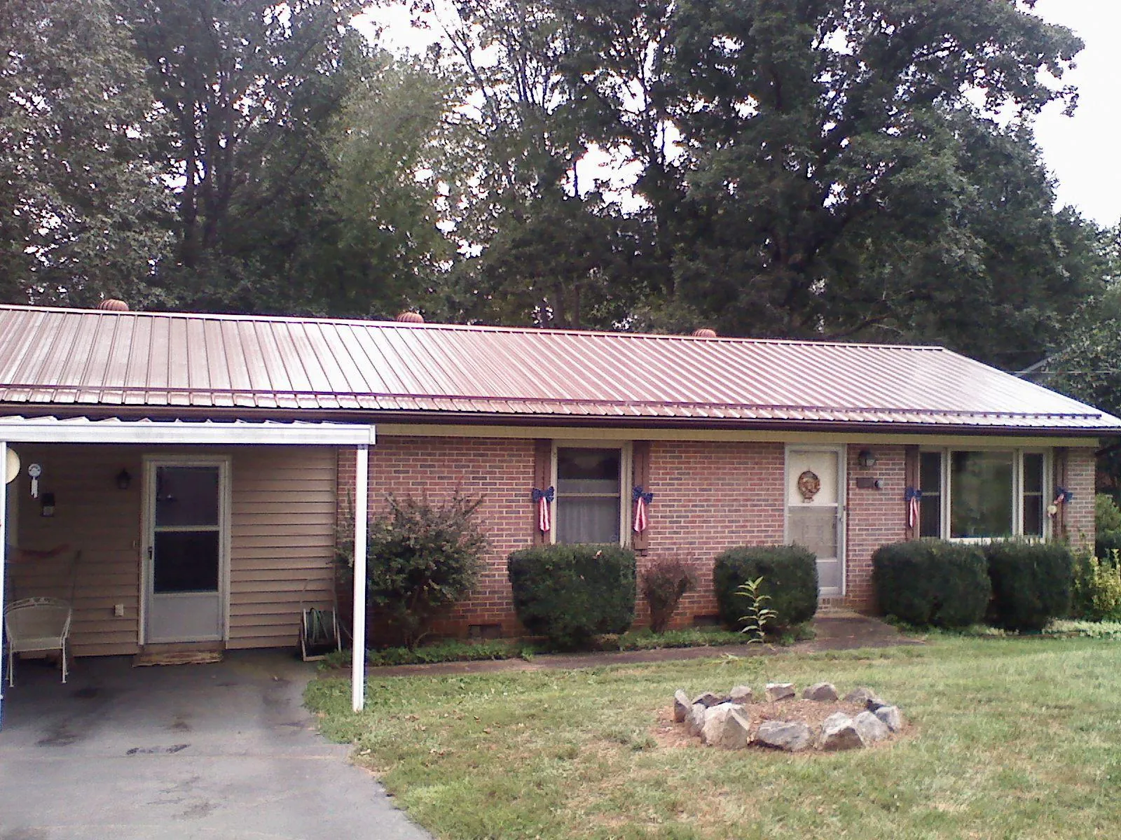 Bronze metal roof and carport on a brick ranch home — Roof Repair work by our crew in Reedville